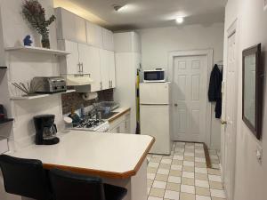 eine Küche mit weißen Schränken und einem weißen Kühlschrank in der Unterkunft Upper East Side 1 bedroom in New York