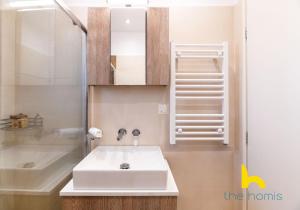 a bathroom with a sink and a shower at Athenian Sky Retreat: Jacuzzi & Fresh Elegance! in Athens