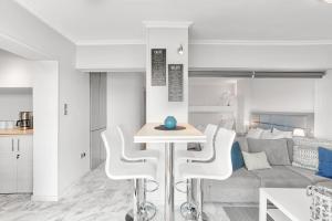 a kitchen and living room with a table and chairs at Chic, Modern Seaside Oasis in Sunny Piraeus! in Piraeus