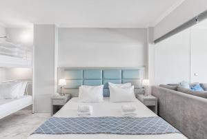 a white bedroom with a bed and a couch at Chic, Modern Seaside Oasis in Sunny Piraeus! in Piraeus