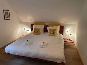 a bedroom with a large white bed with two towels at Two guest-rooms in stylish villa - free bikes in Bruges