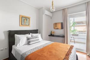 ein Schlafzimmer mit einem Bett und einem großen Fenster in der Unterkunft Fresh Detailed Stylish Apartment at Acropolis in Athen