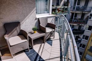 a balcony with two chairs and a table and a window at Cosy apartment Zugló next to Puskás Aréna in Budapest