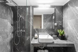 y baño blanco y negro con lavabo y ducha. en Deluxe 3-BDRM Urban-industrial Apt at Acropolis, en Atenas