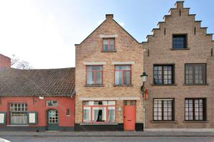 a brick building with a red door on a street at Charming townhouse in historic centre of Bruges in Bruges