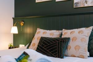a bedroom with a bed with pillows and a green wall at Huswell - Stylish studio in the heart of Bruges in Bruges