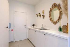 a bathroom with a sink and a mirror on the wall at Huswell - Stylish studio in the heart of Bruges in Bruges