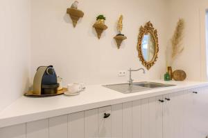 a kitchen counter with a sink and a mirror at Huswell - Stylish studio in the heart of Bruges in Bruges
