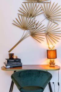 a table with a green chair and a lamp at Huswell - Stylish studio in the heart of Bruges in Bruges