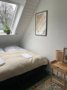 a bed in a room with a window at GÆSTEHUSET in Tarm