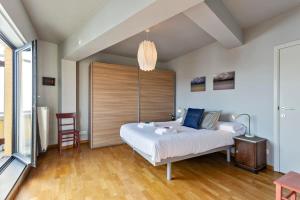 um quarto com uma cama grande e uma cabeceira em madeira em Apartment with spacious terrace and stunning view em Oostende