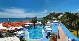 a resort with a large swimming pool next to the ocean at Albatros in Savona