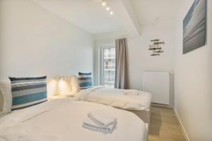 1 Schlafzimmer mit 2 Betten und einem Fenster in der Unterkunft Majestic Apartment With Breathtaking Sea View in De Haan