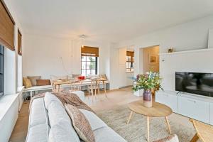 uma sala de estar com um sofá e uma mesa em Renovated apartment nearby the beach in Knokke-Heist em Knokke-Heist