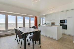 eine Küche und ein Esszimmer mit einem Tisch und Stühlen in der Unterkunft Majestic Apartment With Breathtaking Sea View in De Haan