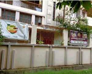 a fence in front of a building with signs on it at The Lemon Chile in Rānchī