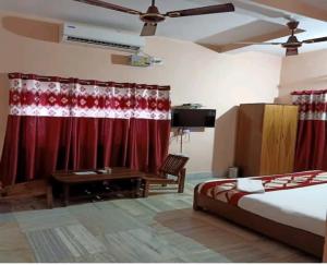 a bedroom with a bed and red curtains at The Lemon Chile in Rānchī