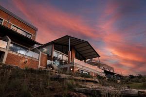 ein Gebäude mit wolkigem Himmel im Hintergrund in der Unterkunft Dragonview Lodge in Winterton