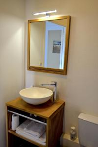 a bathroom with a bowl sink and a mirror at Hôtel Alizéa in La Rochelle
