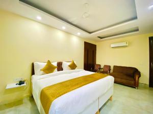 a bedroom with a large bed and a couch at Hotel Saket Place - Near Saket Metro in New Delhi