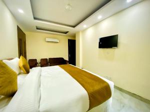 a bedroom with a bed and a flat screen tv at Hotel Saket Place - Near Saket Metro in New Delhi
