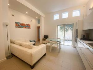 uma sala de estar com um sofá branco e uma mesa em Gizimin, Stylish, modern, central apartment em Tal-Għoqod
