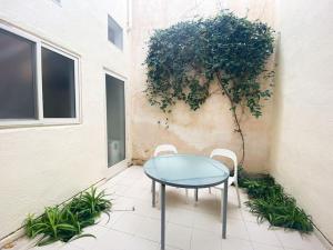 uma mesa e cadeiras num pátio ao lado de um edifício em Gizimin, Stylish, modern, central apartment em Tal-Għoqod