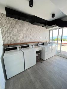 a laundry room with three sinks and two washers at Fedua - Unique Apartment in Guatemala