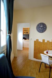 Pokój z zegarem na ścianie i stołem w obiekcie Hôtel Alizéa w La Rochelle