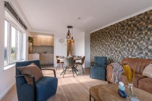 a living room with a couch and a table at Huswell - Cosy apartment with vintage interior in De Haan
