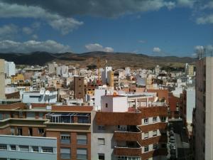 a city with buildings and mountains in the background at Calle Juan Lirola in Almería