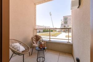 a balcony with two chairs and a large window at Luxurious flat "de zilte zeezoen" close to the sea in Ostend