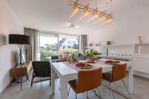 a kitchen and dining room with a white table and chairs at Luxuriously appointed apartment with lovely terrace and private parking in Blankenberge