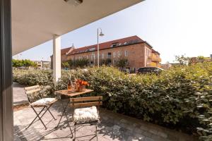 un patio avec une table et des chaises et un bâtiment dans l'établissement Luxuriously appointed apartment with lovely terrace and private parking, à Blankenberge