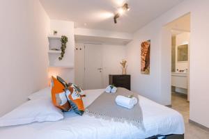 a bedroom with a large white bed with pillows at Luxuriously appointed apartment with lovely terrace and private parking in Blankenberge