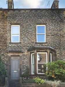 a brick house with a door and two windows at Number 61 Skipton in Skipton