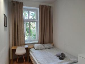 um pequeno quarto com uma cama e uma janela em Kwatery Oliwka em Sopot