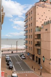 uma rua ao lado de um edifício e da praia em Spacious two bedroom apartment in Knokke em Knokke-Heist