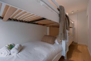 um quarto com um beliche branco e toalhas em Spacious two bedroom apartment in Knokke em Knokke-Heist