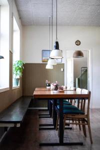 una sala da pranzo con tavolo e sedie in legno di GÆSTEHUSET a Tarm