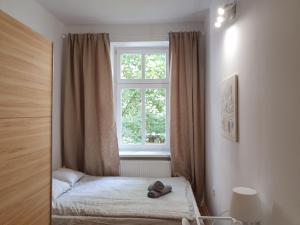 um pequeno quarto com uma janela e uma cama em Kwatery Oliwka em Sopot