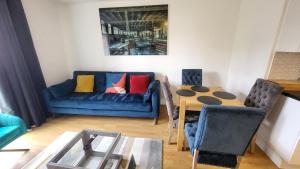 a living room with a blue couch and a table at Garland Central City Apartment London 2 in London