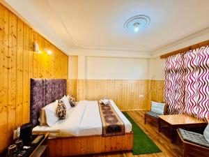 a bedroom with a bed and a bench in a room at The Suraj lodge, Hadimba Road Manali in Manāli