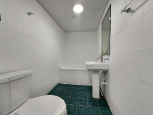 a white bathroom with a toilet and a sink at 오픈스테이 in Koyang