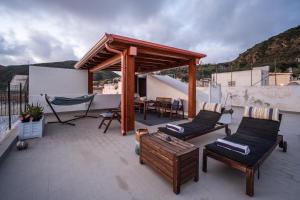 a patio with chairs and a table on a roof at Casa Norma in Lipari