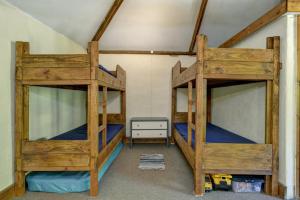 two bunk beds in a room with a room with a bed at The Cart Shed Brendon Hills in Upton