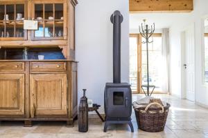 a wood stove in a room with a kitchen at Hofgut Dösterhof - Ferienwohnungen in Wadern +64 photos