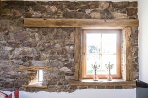 a window in a stone wall with two candles at Hofgut Dösterhof - Ferienwohnungen in Wadern