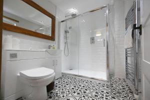 a white bathroom with a shower and a toilet at Avoca Lodge in Fort William +15 photos