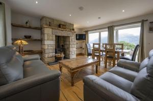a living room with a couch and a fireplace at Avoca Lodge in Fort William